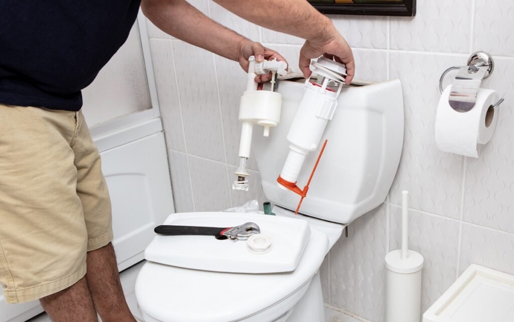 Man using tools repairing toilet in San Diego